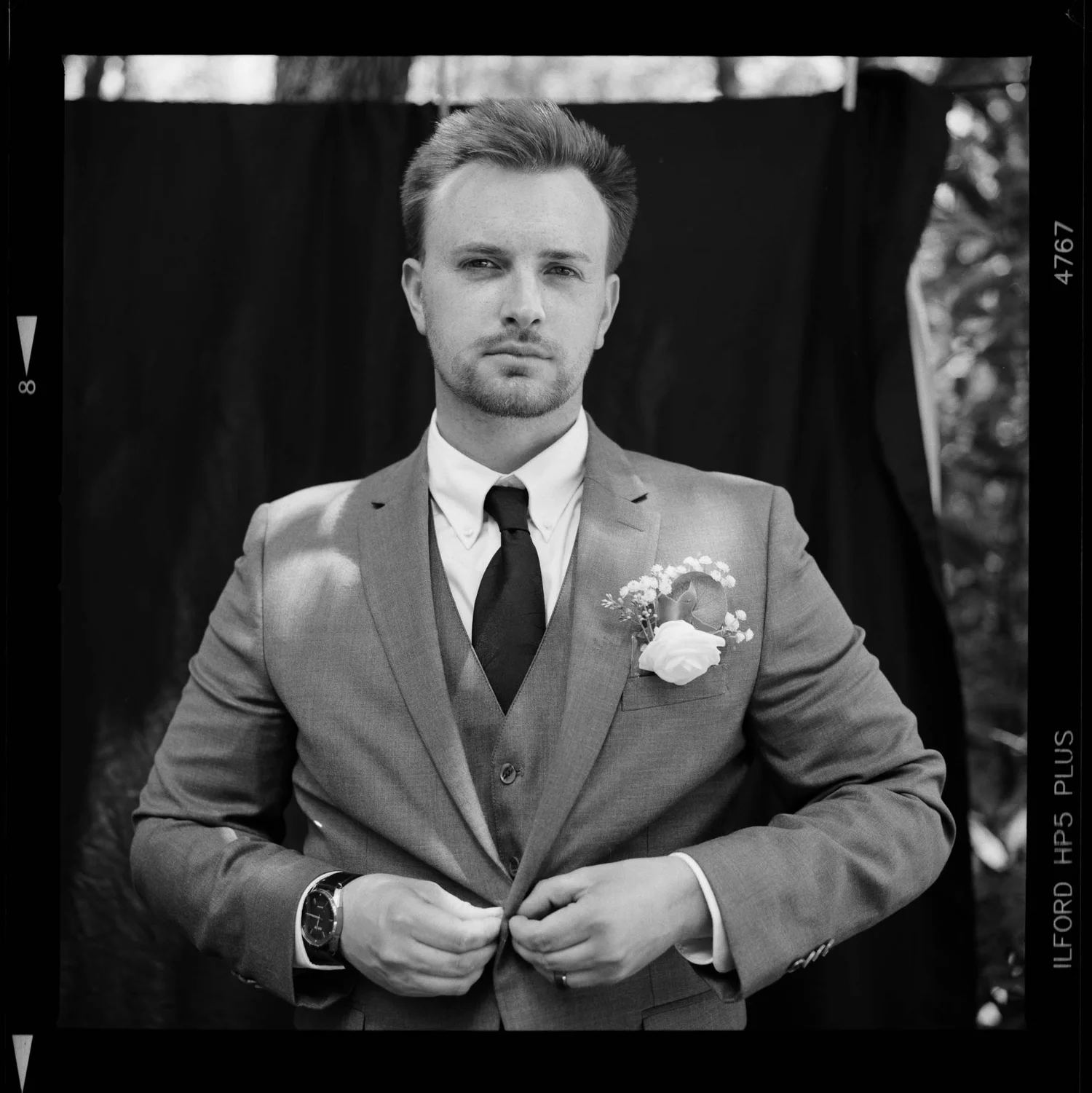 Black and white film portrait of a groom in a suit