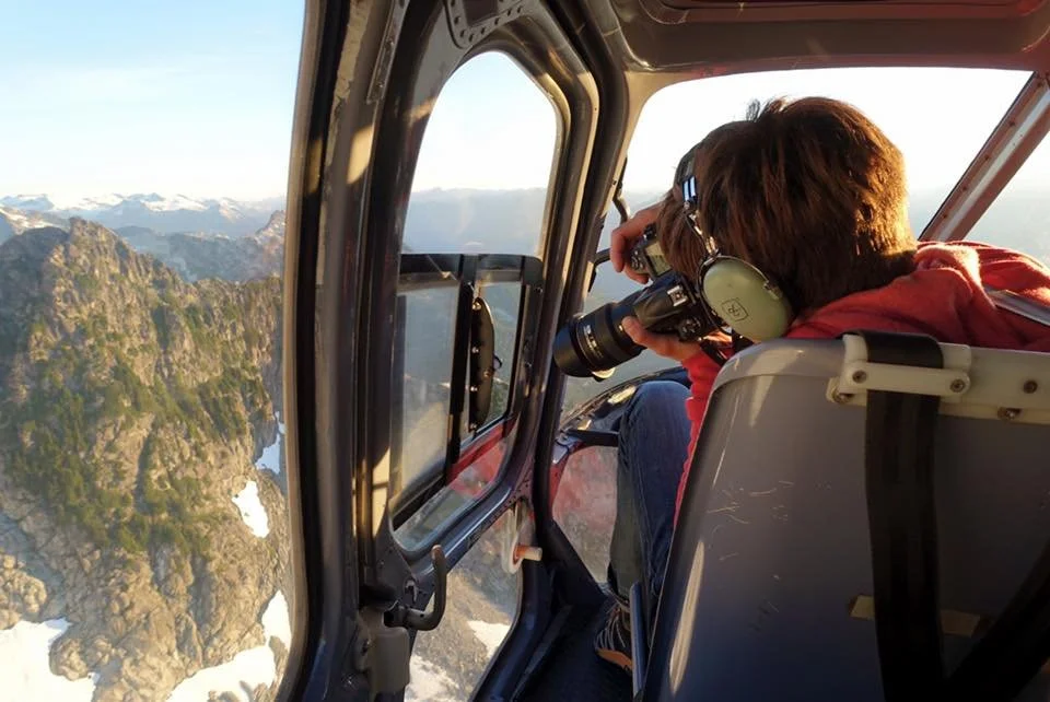 Andy Wickstrom taking photos out the window of a helicopter.