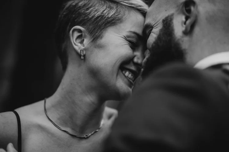 Black-and-white close-up of a couple sharing a quiet moment outdoors