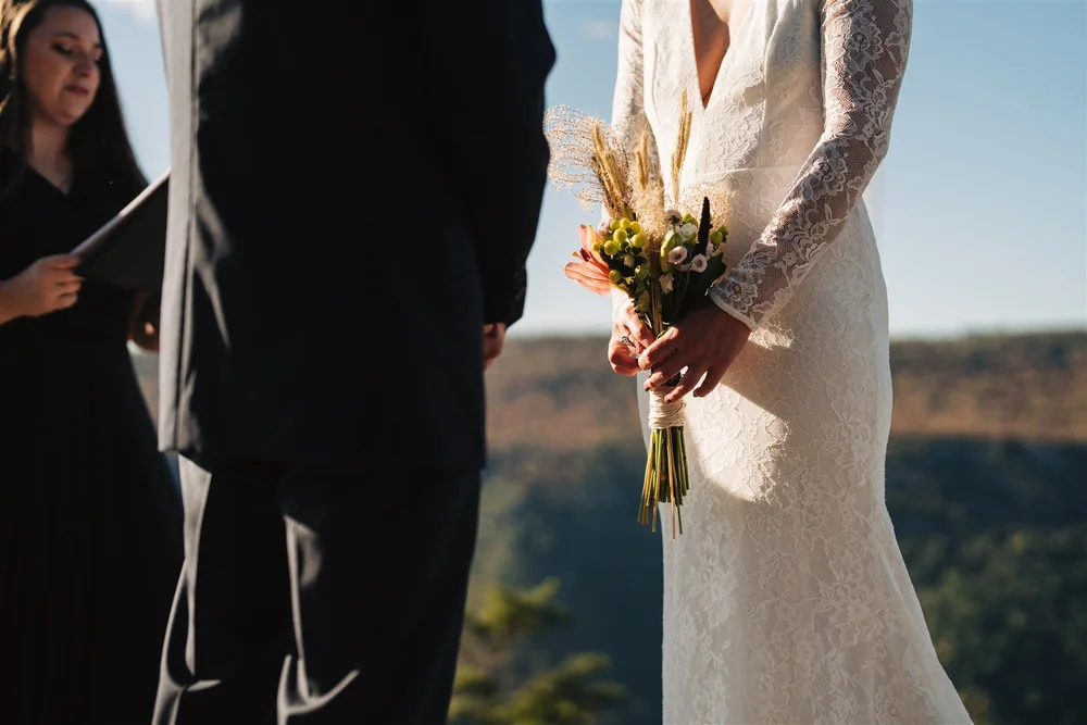 Bride and groom exploring a mountain overlook during their elopement