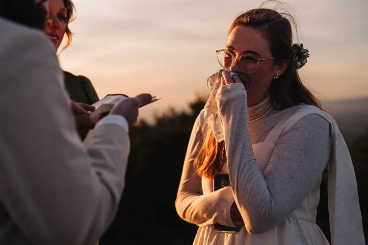 Couple embracing on a rocky mountain overlook in soft early light