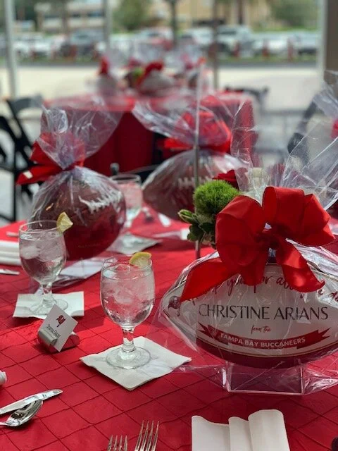 Wrapped footballs with red bows rest on a table. 