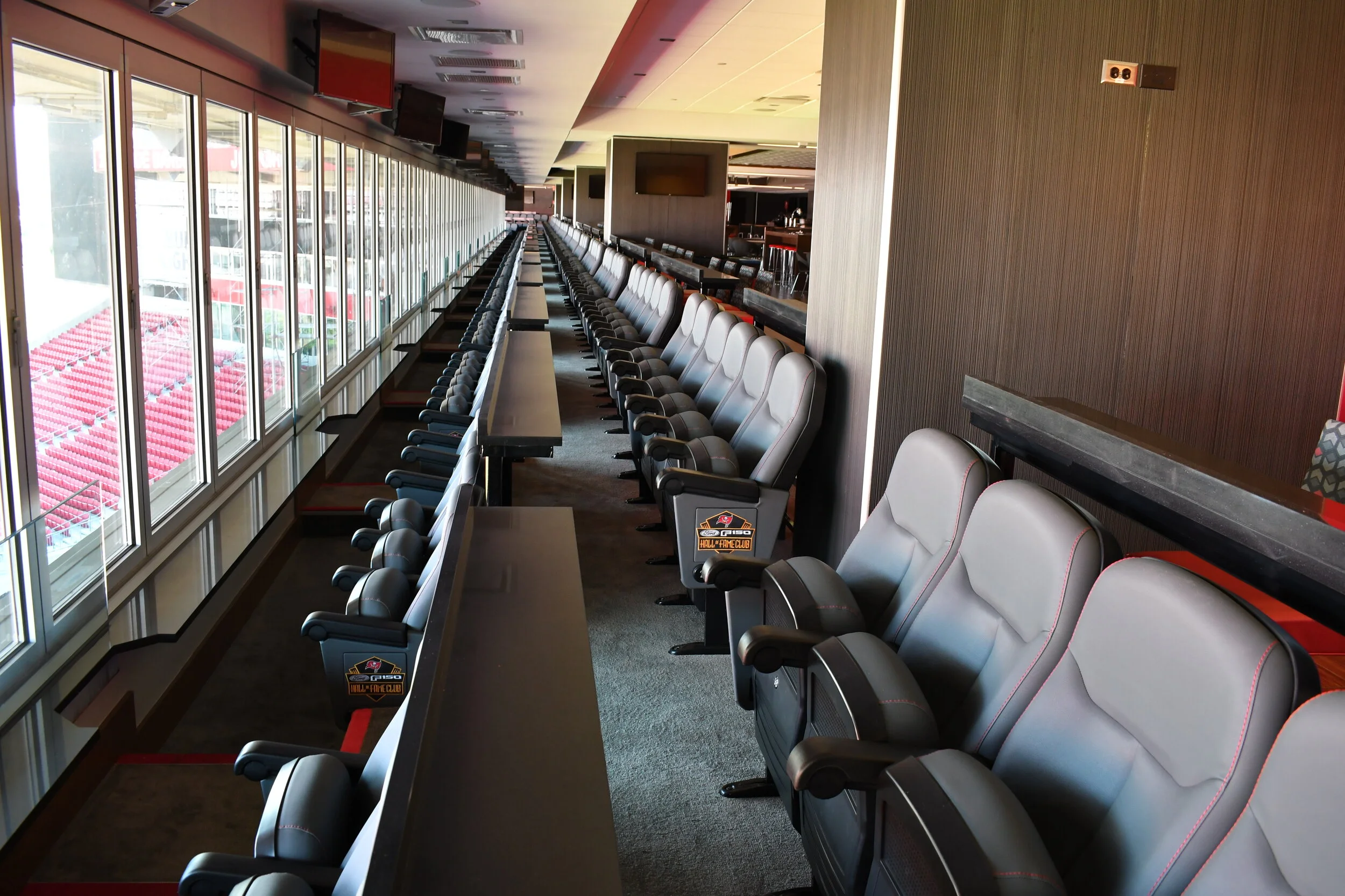 Padded folded chairs overlook the stadium field at the Hall of Fame Club.