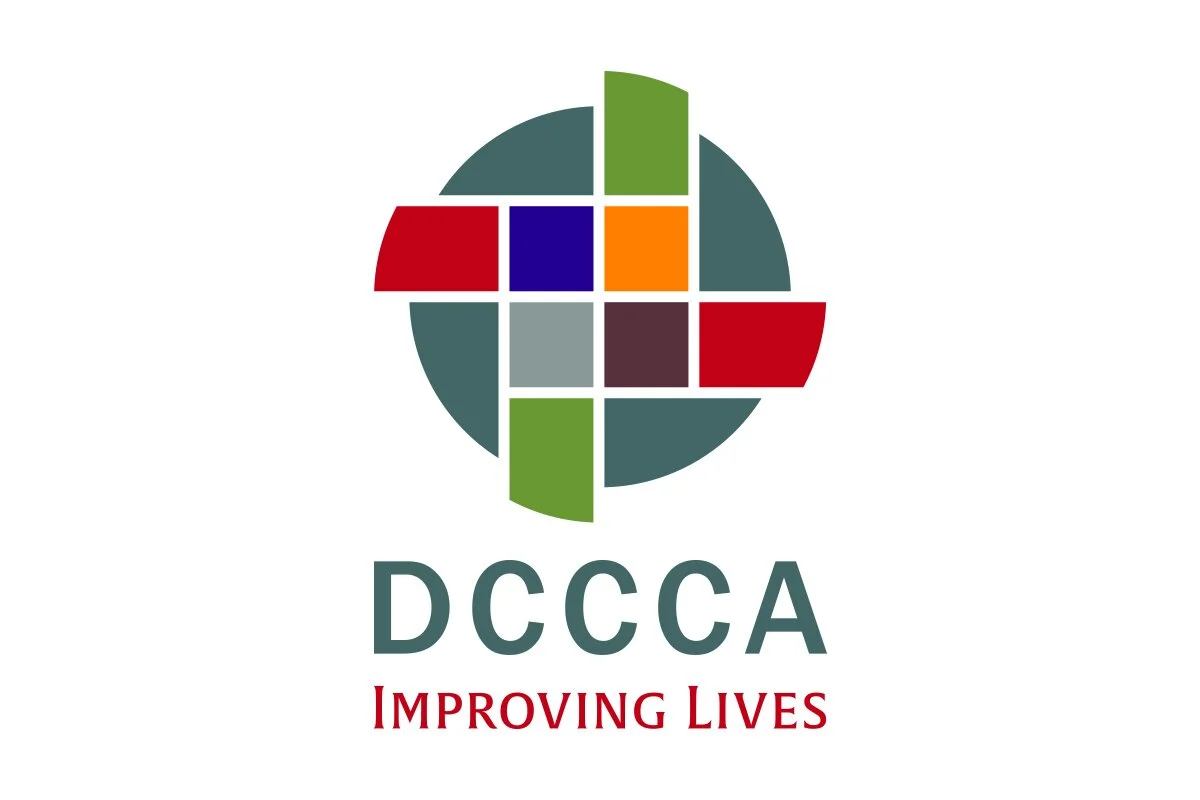 Logo for DCCA with the words 'DCCA' and the slogan 'Improving Lives' below, featuring a circular design made of multicolored squares and rectangles.
