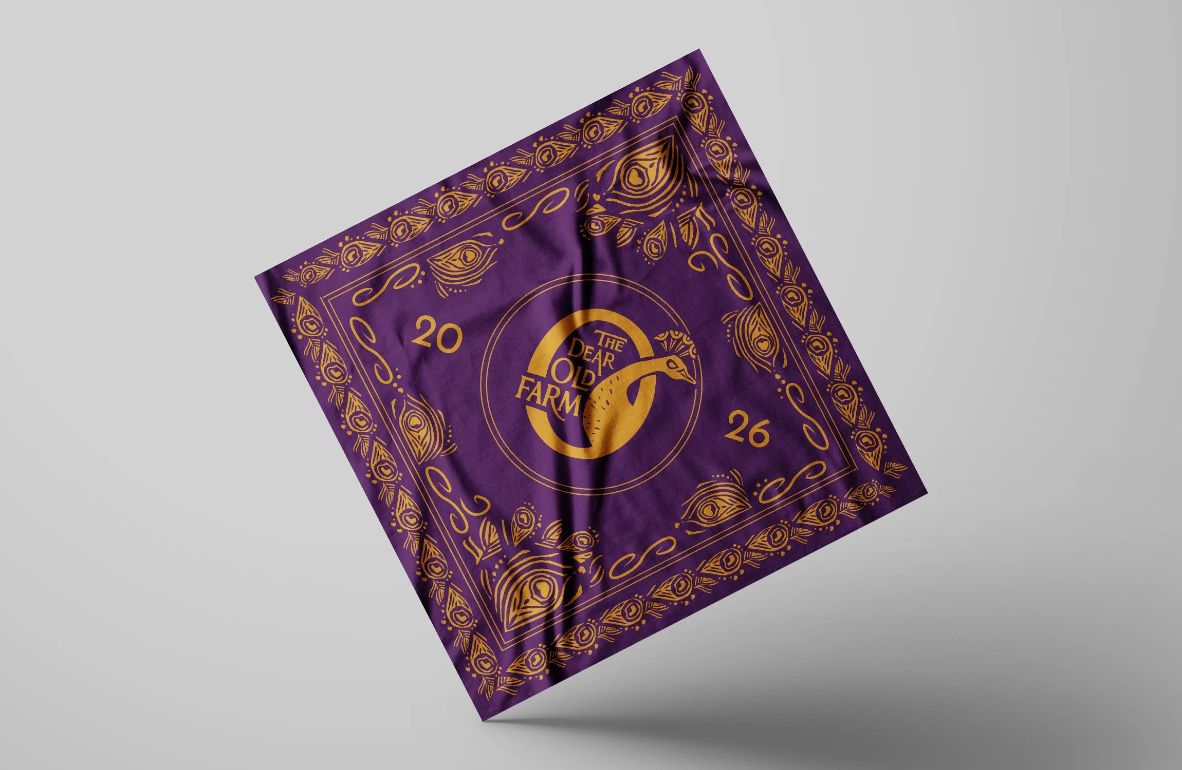 Purple bandana with yellow patterns on it and the Dear Old Farm logo in the center.