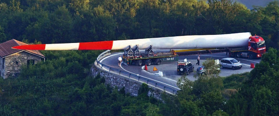 Huge wind turbine blade being moved in a mountain pass