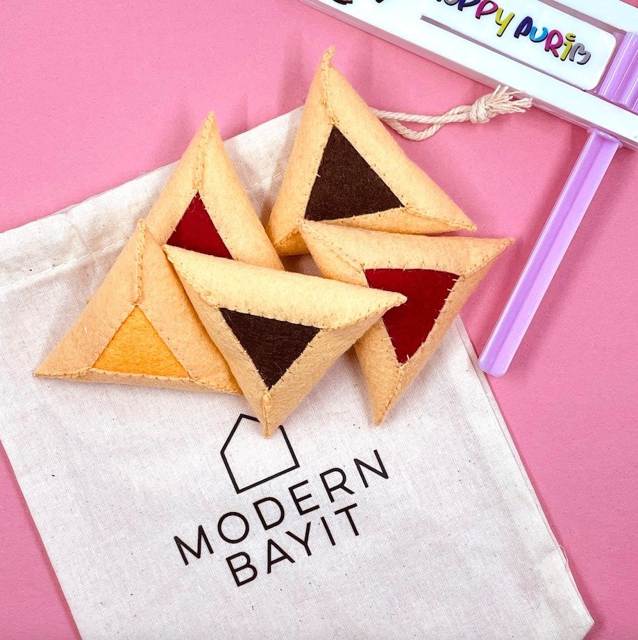 NEW FOR PURIM! 🎉 Get ready to serve up some delicious hamantaschen for you and your friends! Our brand new Felt Hamantaschen Play Set features five scrumptious hamantaschen in three mouthwatering flavours: apricot, strawberry, and chocolate. Crafted