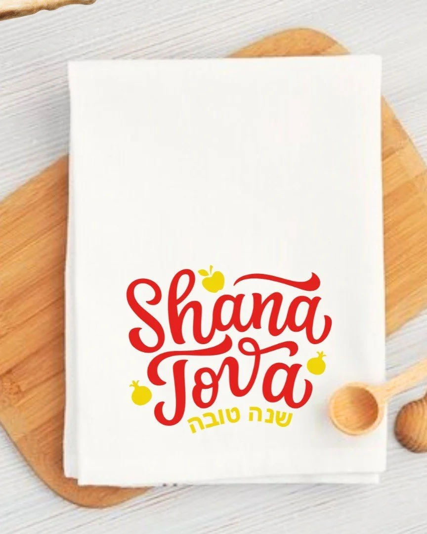 Festive and functional! Our Shana Tova Tea Towel brings the spirit of Rosh Hashanah into your kitchen with a joyful “Shana Tova” design — in English and Hebrew. Perfect for a thoughtful gift, or a festive addition to your own holida