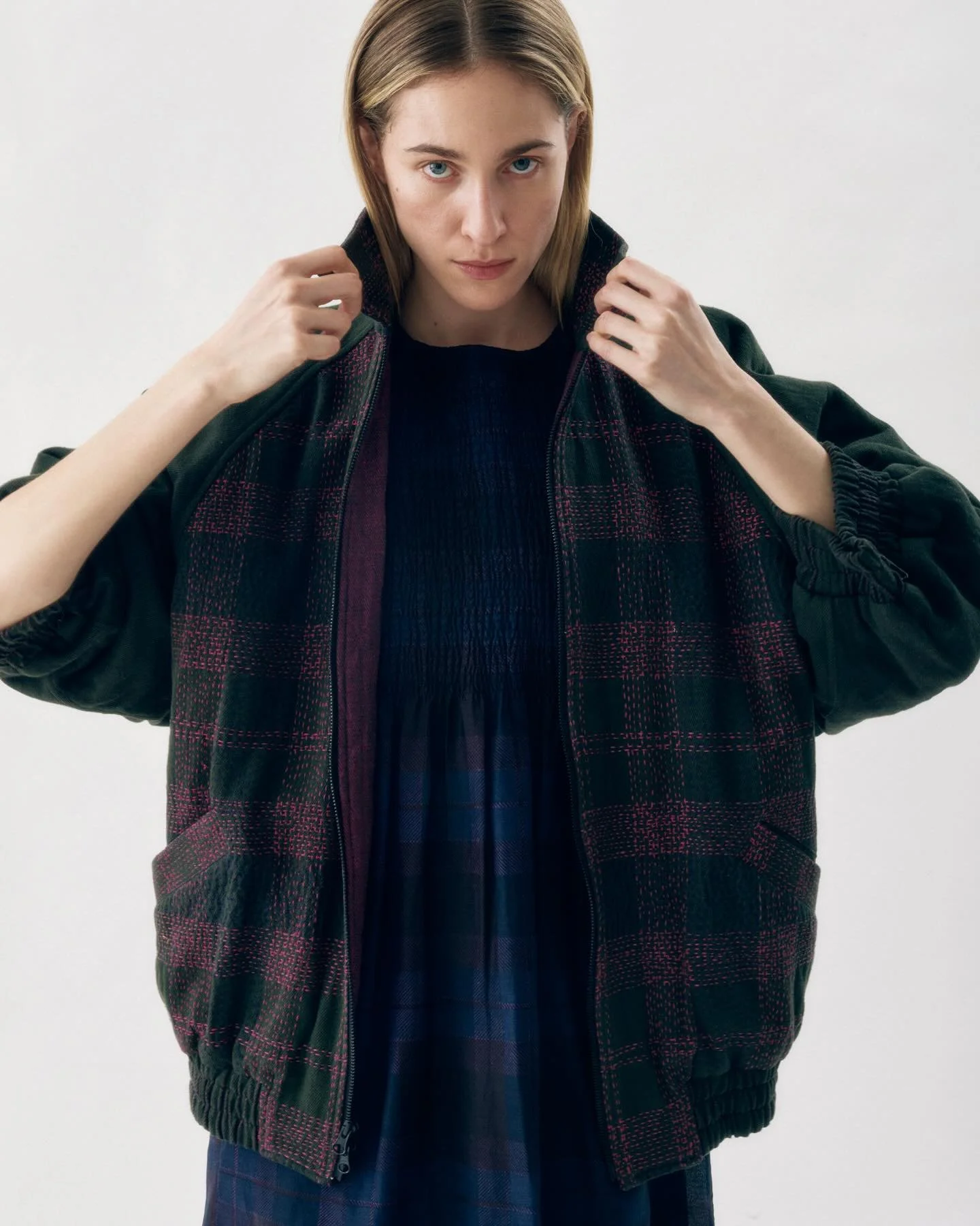 Our Hand embroidered  reversible bomber is here !  A classic oversize raglan sleeve bomber silhouette that can either be worn with the plaid embroidered side out or turned around and worn with the hand woven berry/black quilted side out . 
I have bee