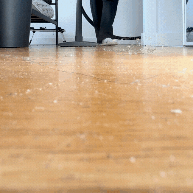 Cleaning in progress at Toronto condo, vacuuming wooden floor in a furnished home.