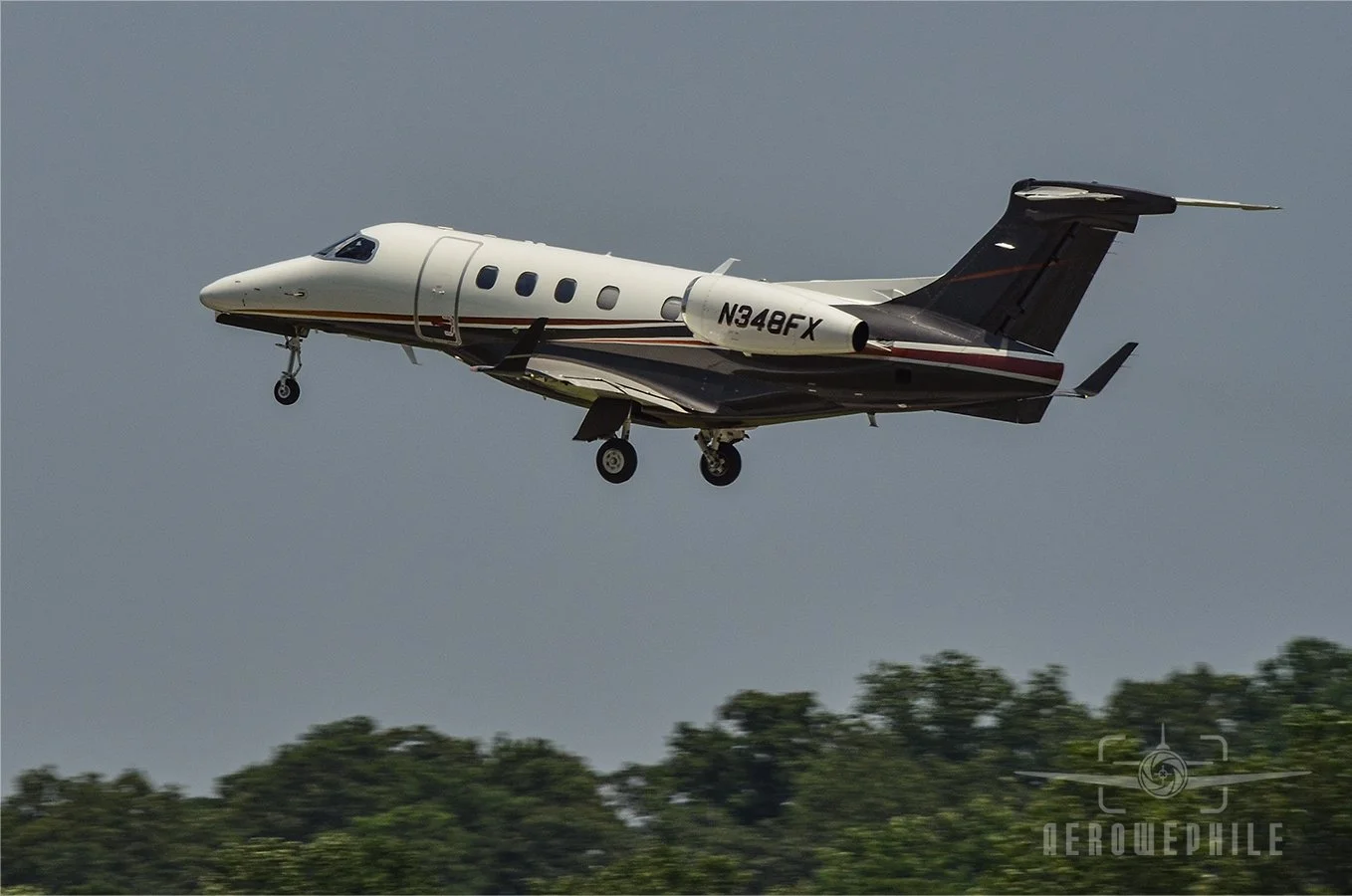 Embraer 505 Phenom 300 taking off.