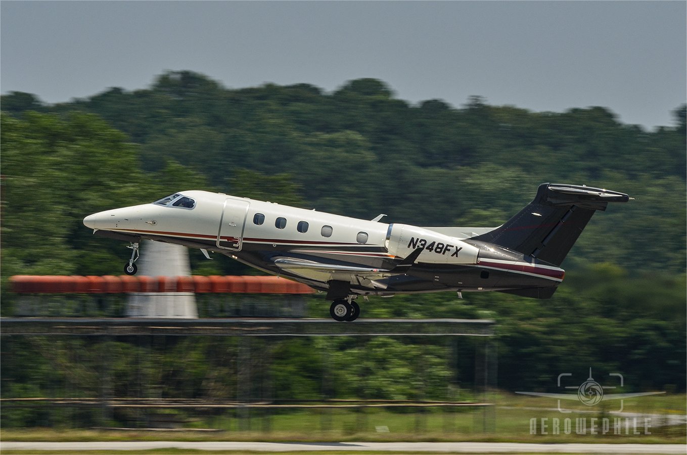 Embraer 505 Phenom 300 taking off.