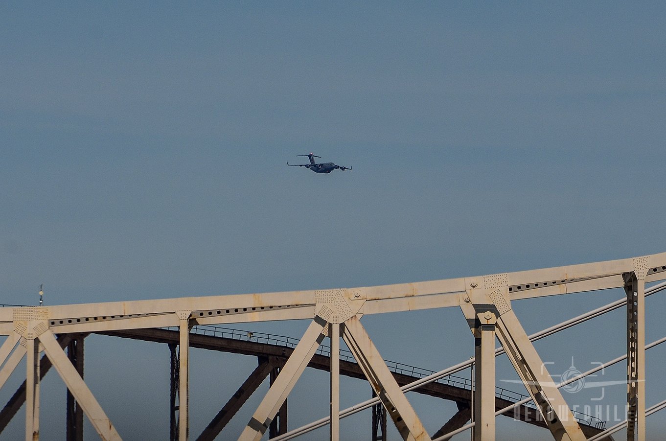 USAF Boeing C-17A Globemaster III passing by off in the distance.