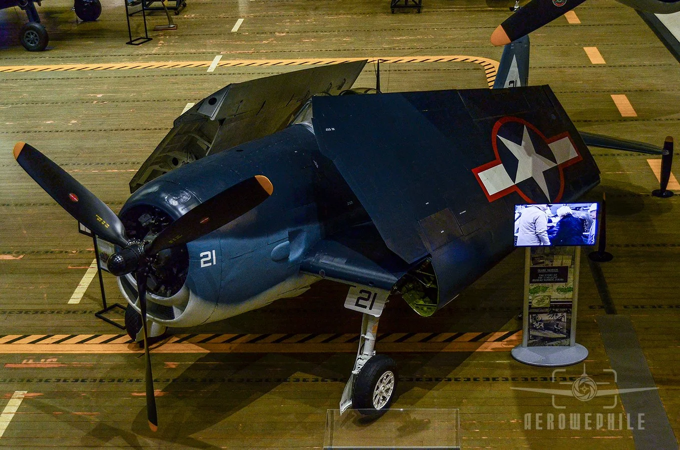 The restored F6F-3 Hellcat on display in the museum. Wearing a temporary paint scheme honoring Jack Taylor, it will eventually wear permanent markings of the squadron in which it service, Fighting Squadron (VF) 38.