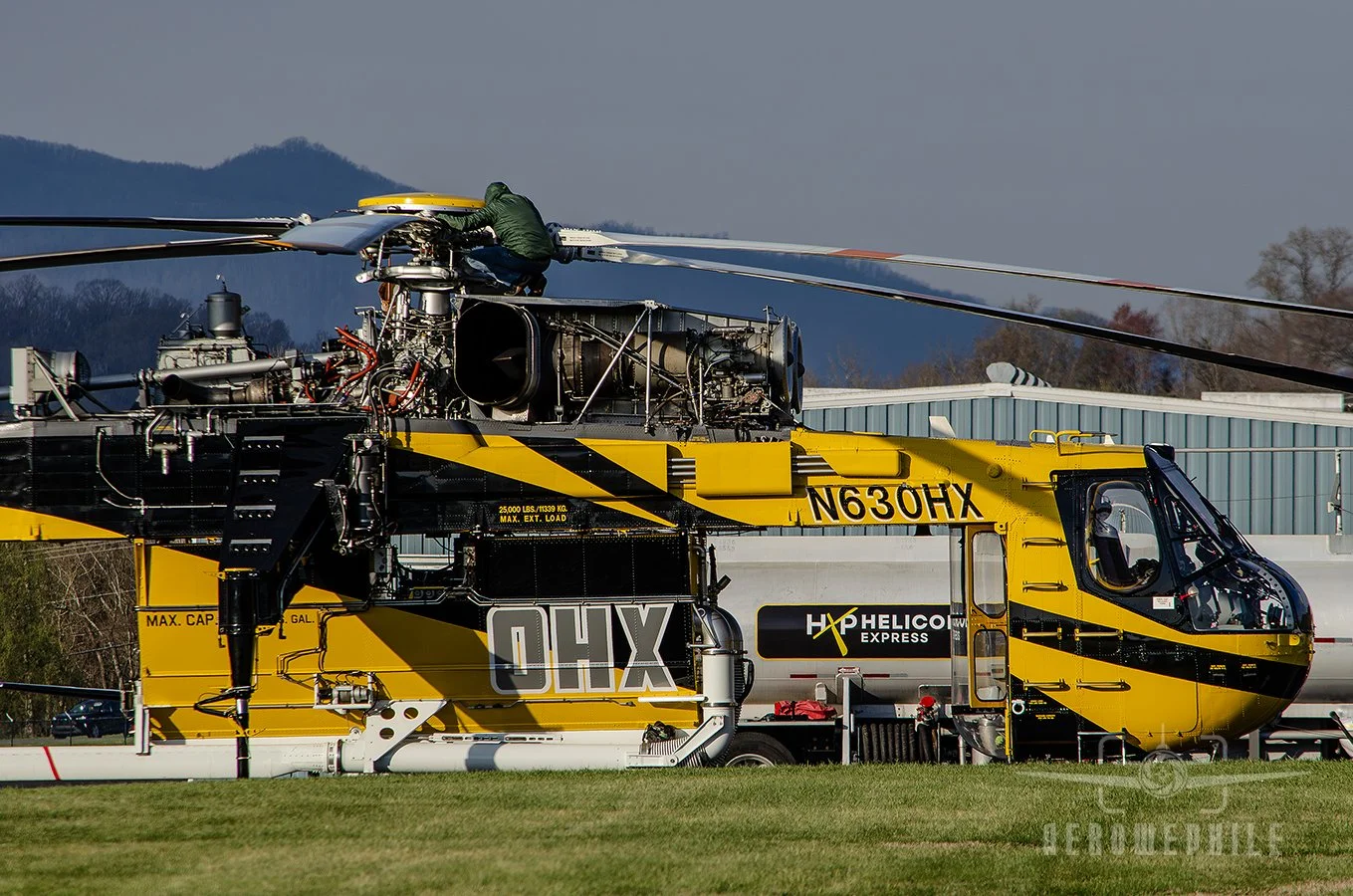 Prior to the Skycrane starting up, a ground crew member making a pre-flight check.
25Mar26