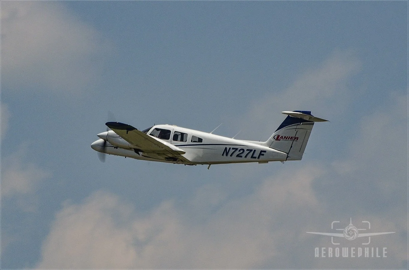 Piper PA-44-180 Seminole with gear up and gaining altitude.