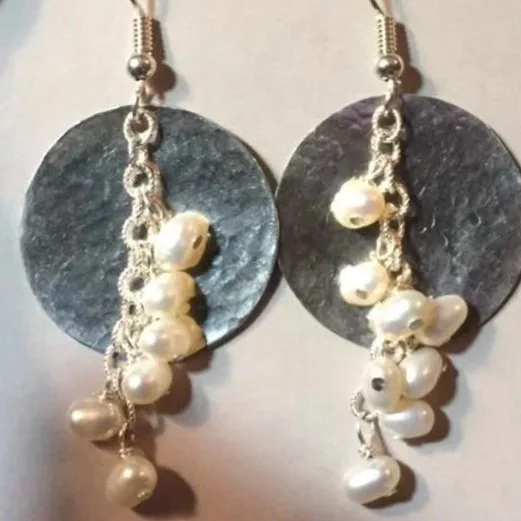 Pair of handmade dangle earrings with large silver disc bases and clusters of white pearls hanging from the chains. The earrings are displayed on a card that says "Handmade by Kathy Romero."