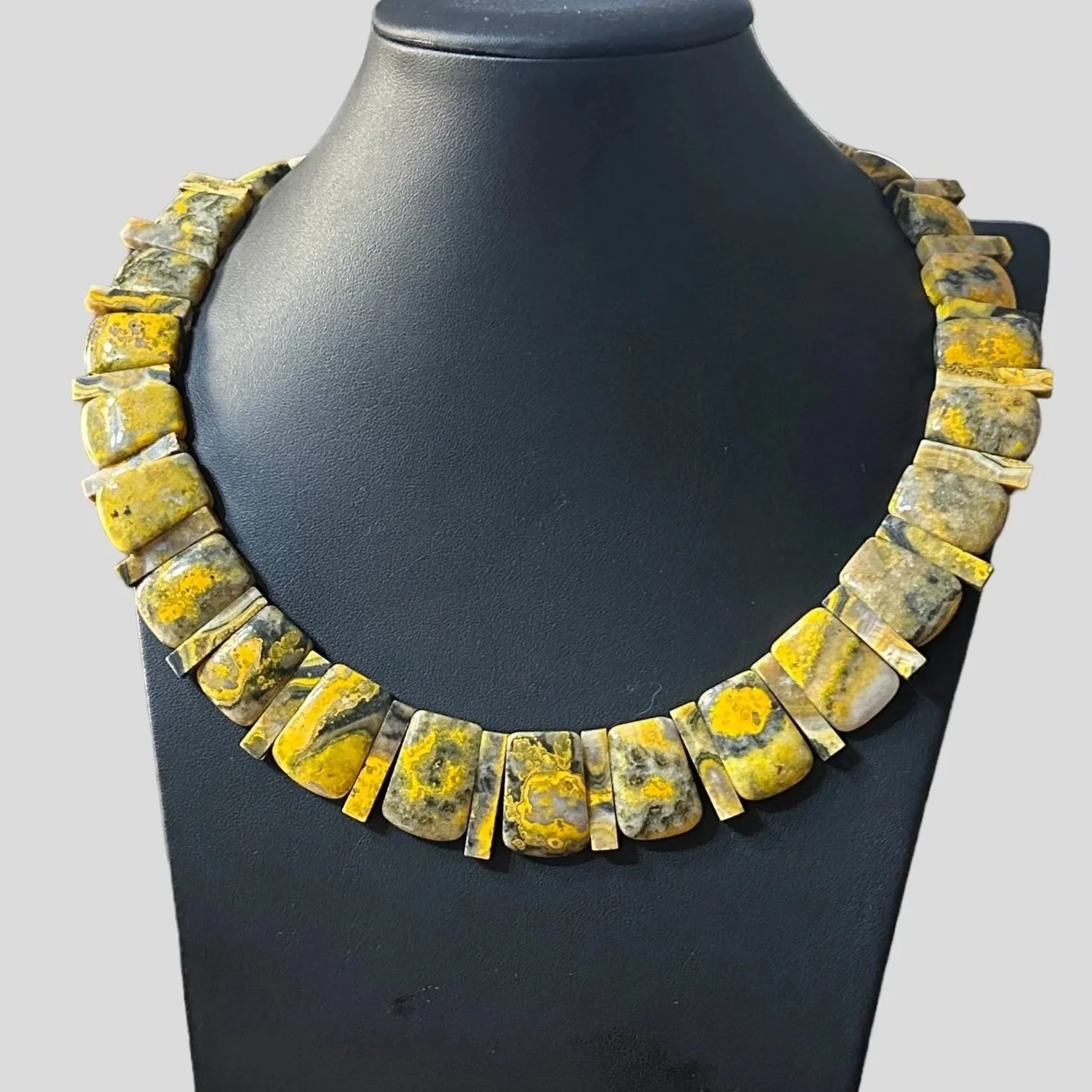 Yellow and gray patterned beaded necklace on a black display bust, with the text 'Victoria's Southwest Designs' at the bottom.