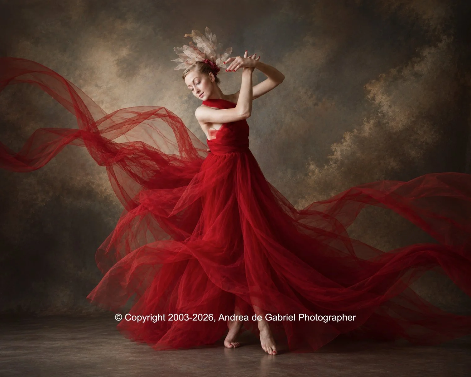 A woman dancing in a flowing red dress with a floral headpiece against a textured brown background.