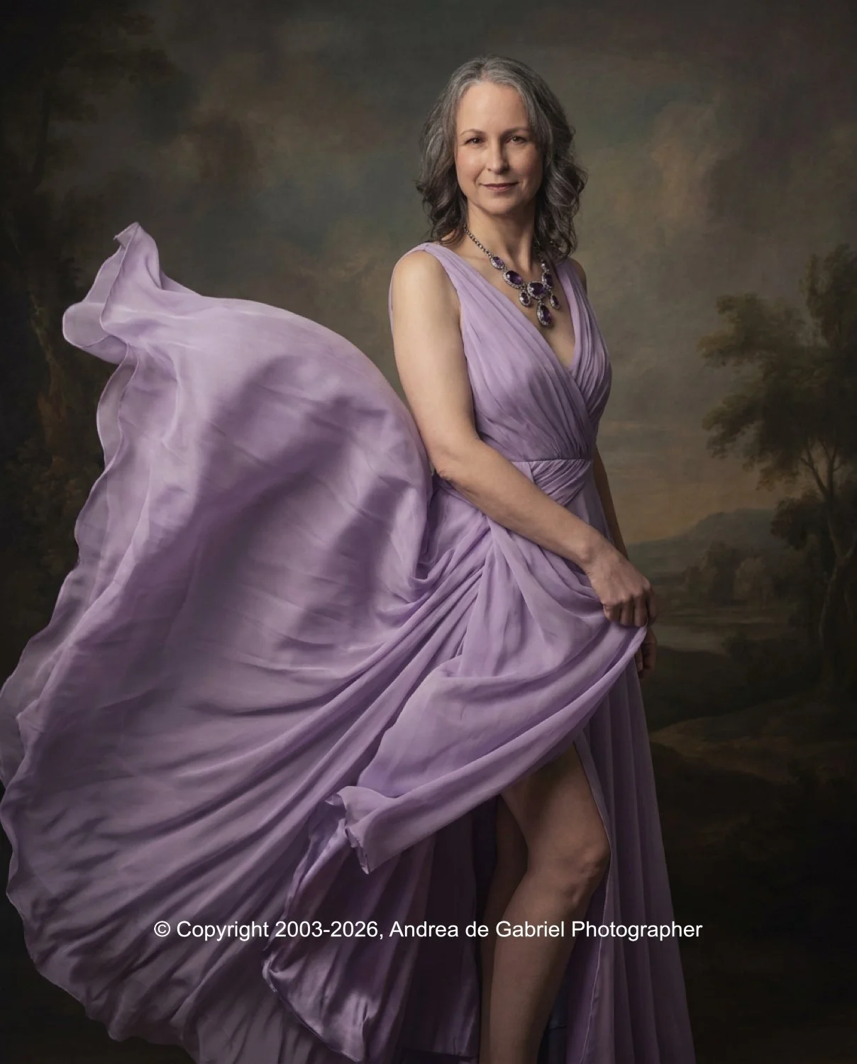 A woman with gray hair in a purple gown with a flowing train, standing in front of a landscape backdrop with trees and hills.