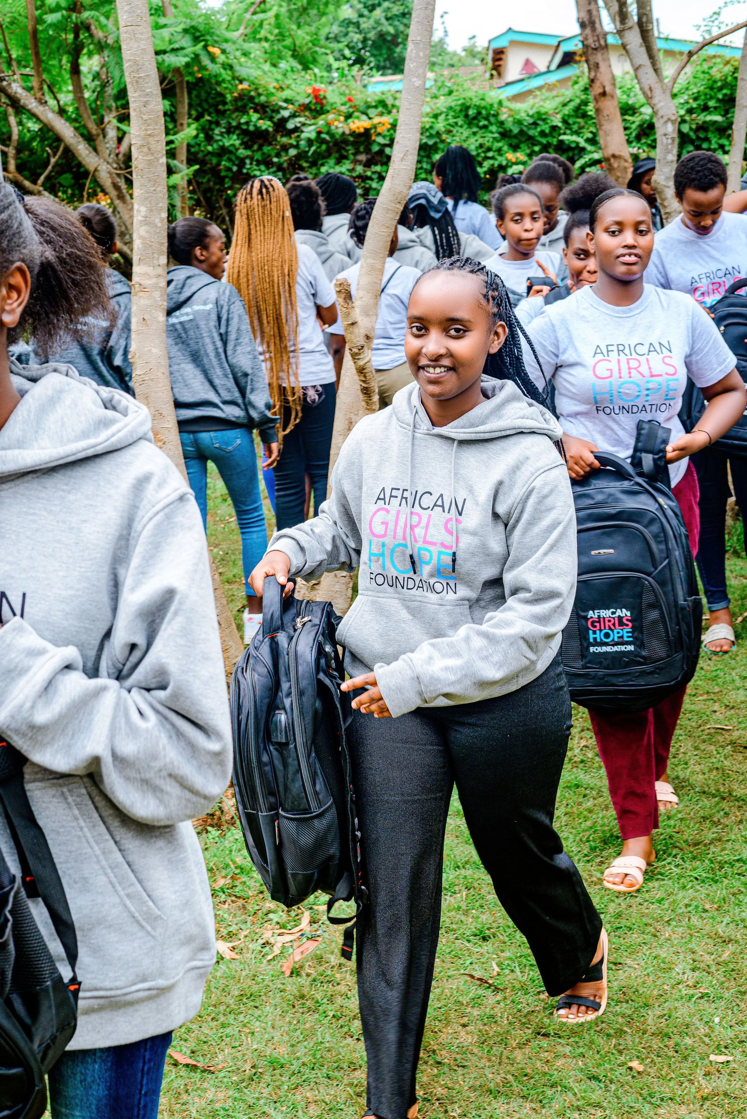 African refugee girl receiving a donation of a backpack for school.