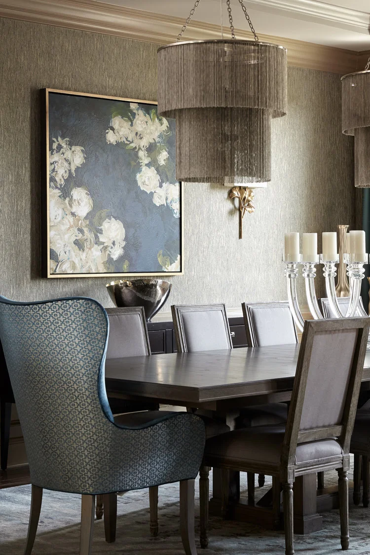 luxurious dining room with host chairs, traditional side chairs, Vanguard furniture table, floral art, textured wallpaper, old hollywood glamour, global views candlesticks, candlesticks, arteriors chandeliers, silk draperies, Vanguard sideboard, wood
