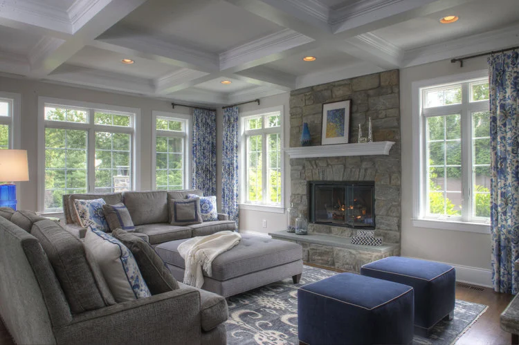 family room, blue, ikat rug, ikat, hand knotted rug, custom drapery, Robert Allen, Vanguard furniture, custom home, grey, velvet, chenille sofa, ottoman, cobalt, Arteriors, stone fireplace, stonework, masonry, coffered ceiling, cube ottomans,  hardwo