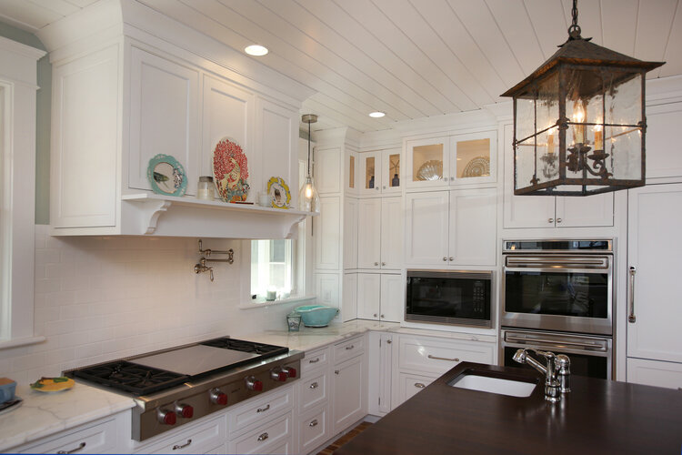 Custom white kitchen with wolf range, hand made plates from Anthropologie, soapstone countertops, currey and co lantern, metal lantern, wood stove hood, marble counter top, Interior design, interior designer, home design, home decor, interiors, desig