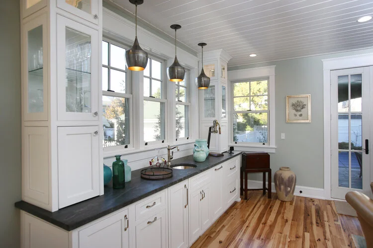 Custom wet bar with white cabinets and soapstone top, bar sink, wood floors, french doors, arteriors steel and brass pendants, glass shelves, glass doors, elephant, Buck homes, Ocean city NJ, art, patioInterior design, interior designer, home design,