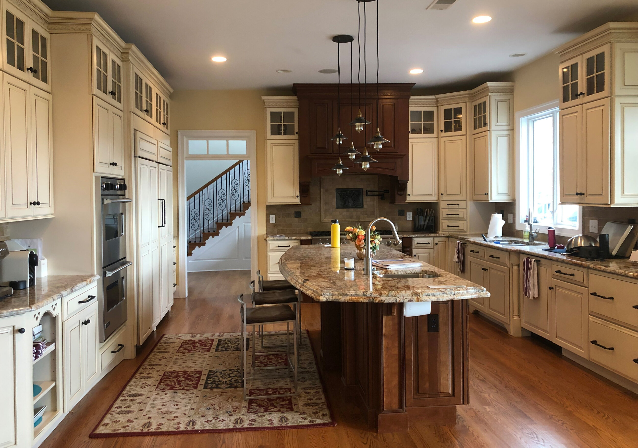  outdated kitchen, dark wood hood, cream cabinets, yellow walls 