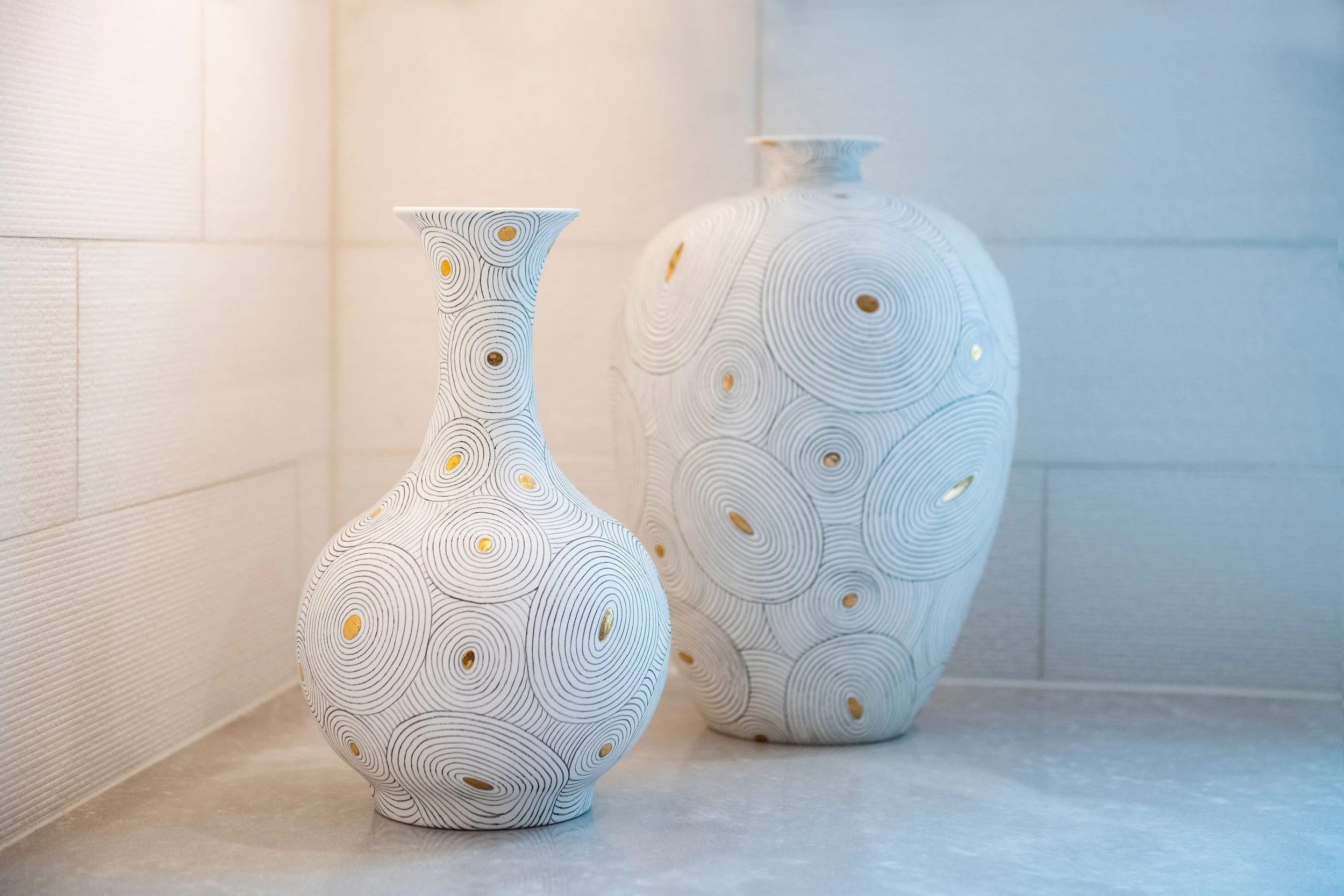 contemporary and bright kitchen with custom white and wood cabinets, white island, natural stone countertops, pendants, light boxes, gold zip drain, wolf range, double oven, coffee compartment, hidden microwave,  hardwood floors,  Interior design, in