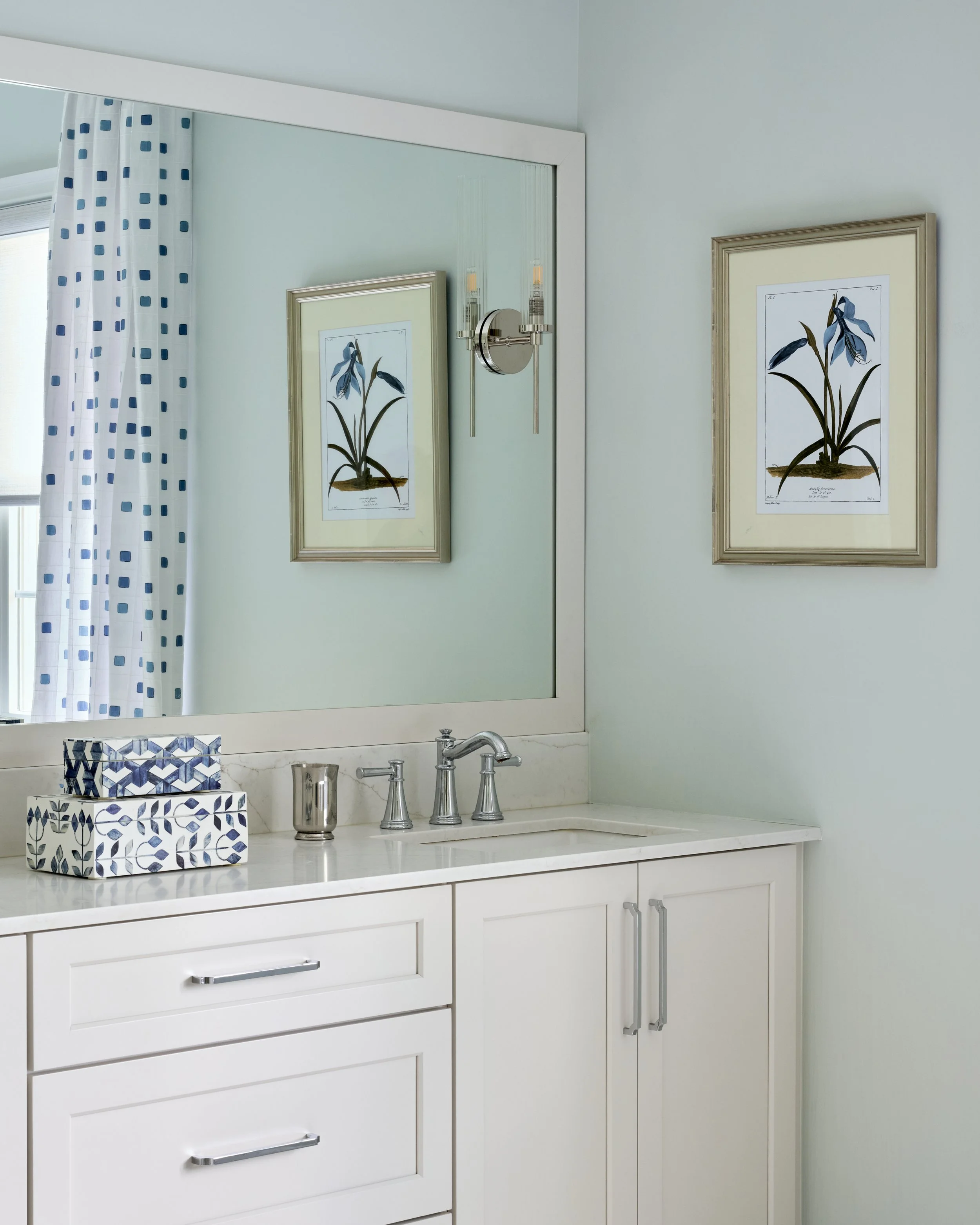 light bright airy clean sleek soothing primary bathroom with double vanity, elegant chandelier, patterned drapery, and free standing soaking tub