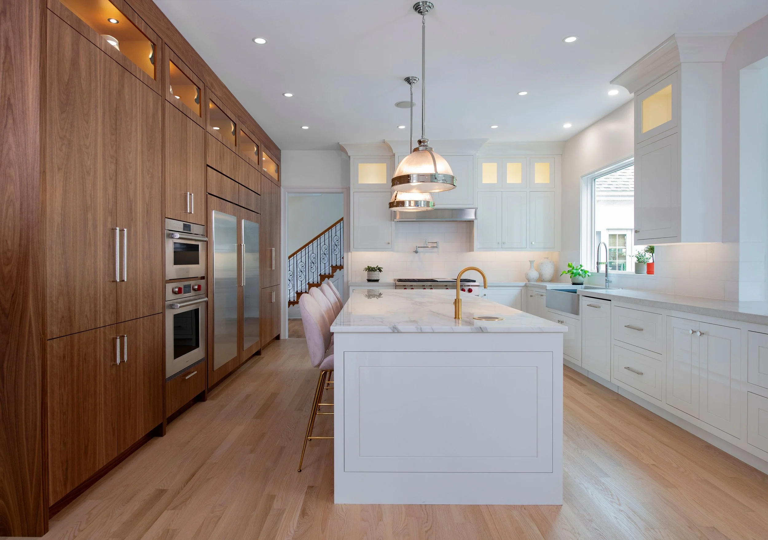 contemporary and bright kitchen with custom white and wood cabinets, white island, natural stone countertops, pendants, light boxes, gold zip drain, wolf range, double oven, coffee compartment, hidden microwave,  hardwood floors,  Interior design, in