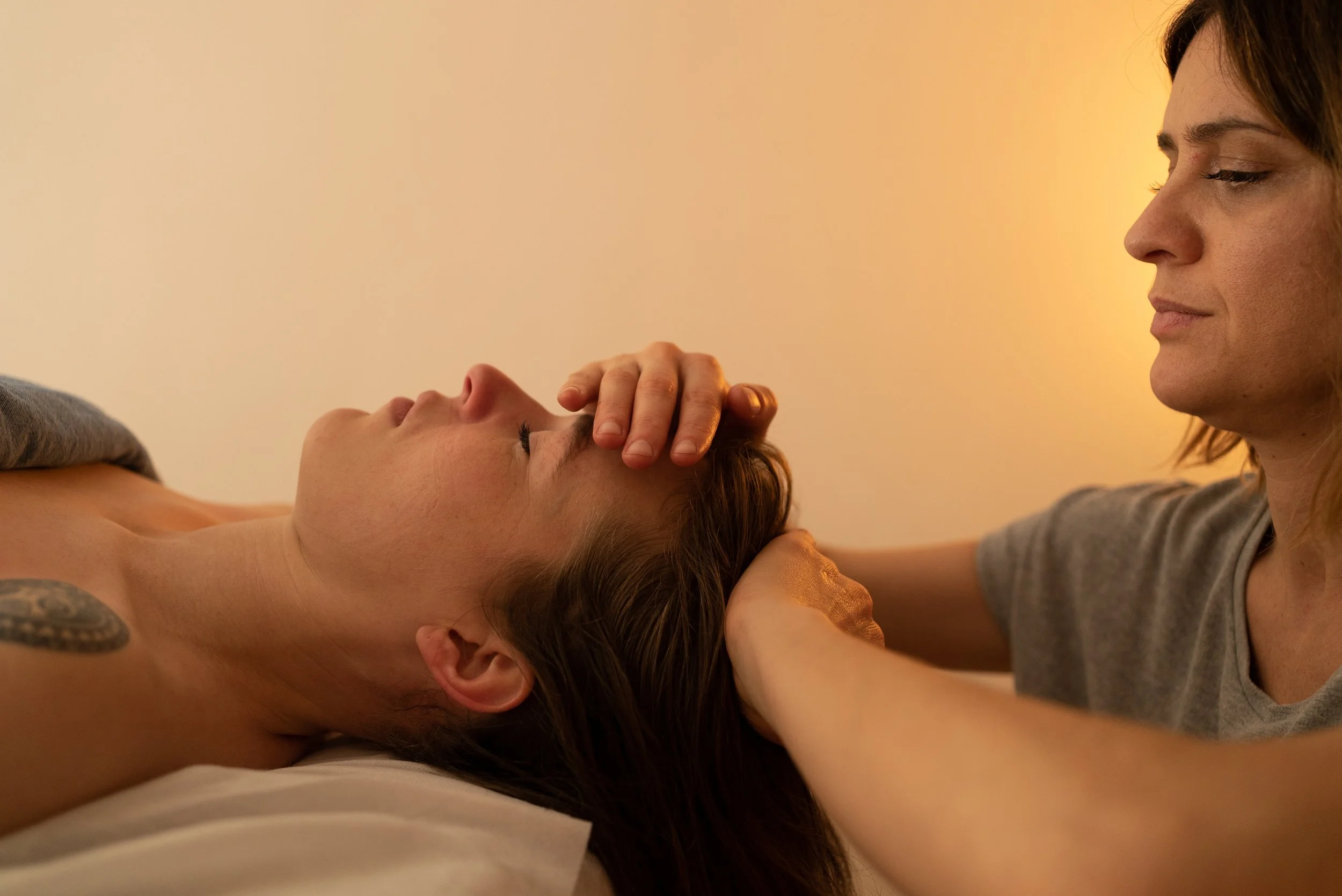 Hands touching a woman's head to relax her