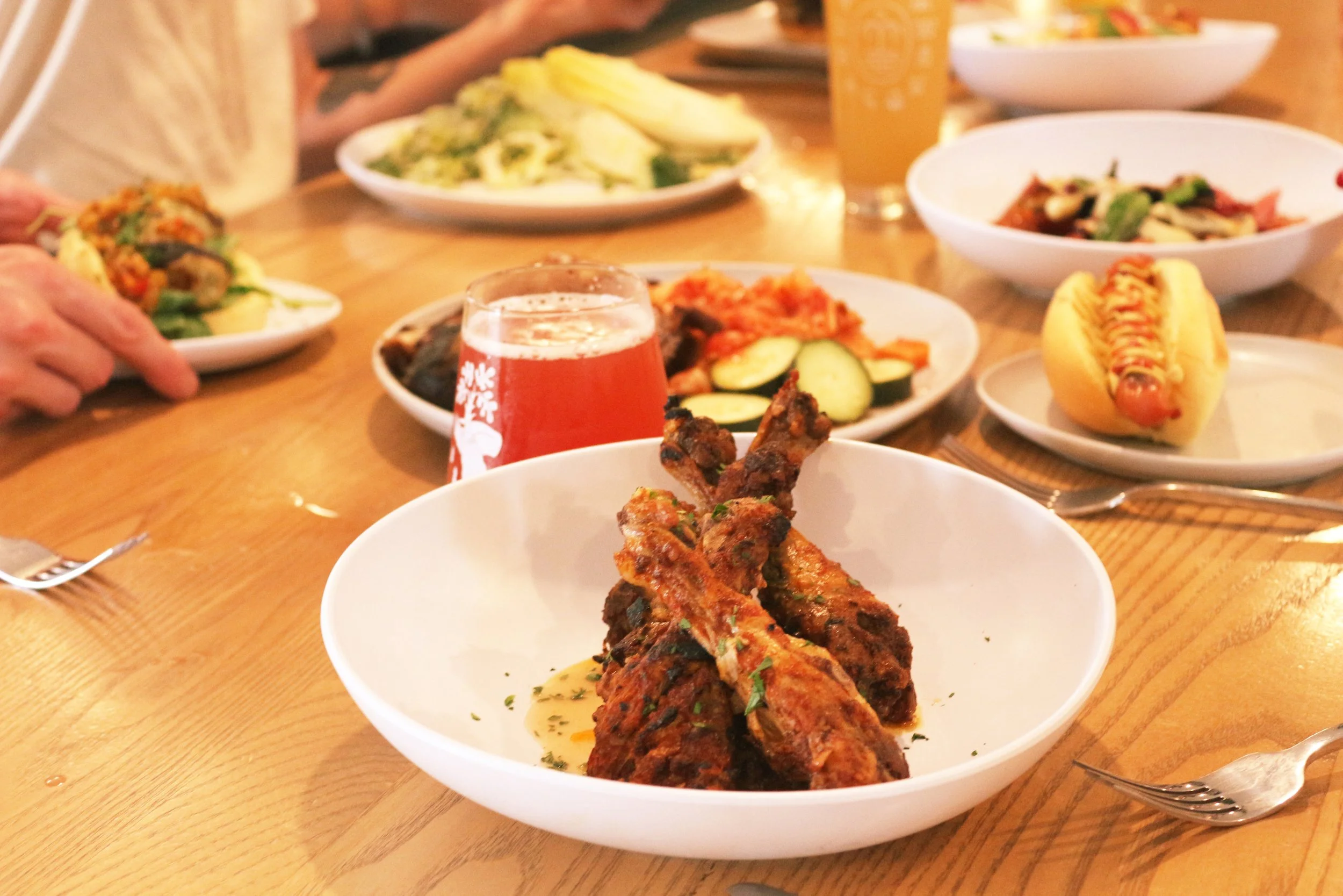 Plate of grilled meat, likely lamb or beef, garnished with herbs, on a white dish.