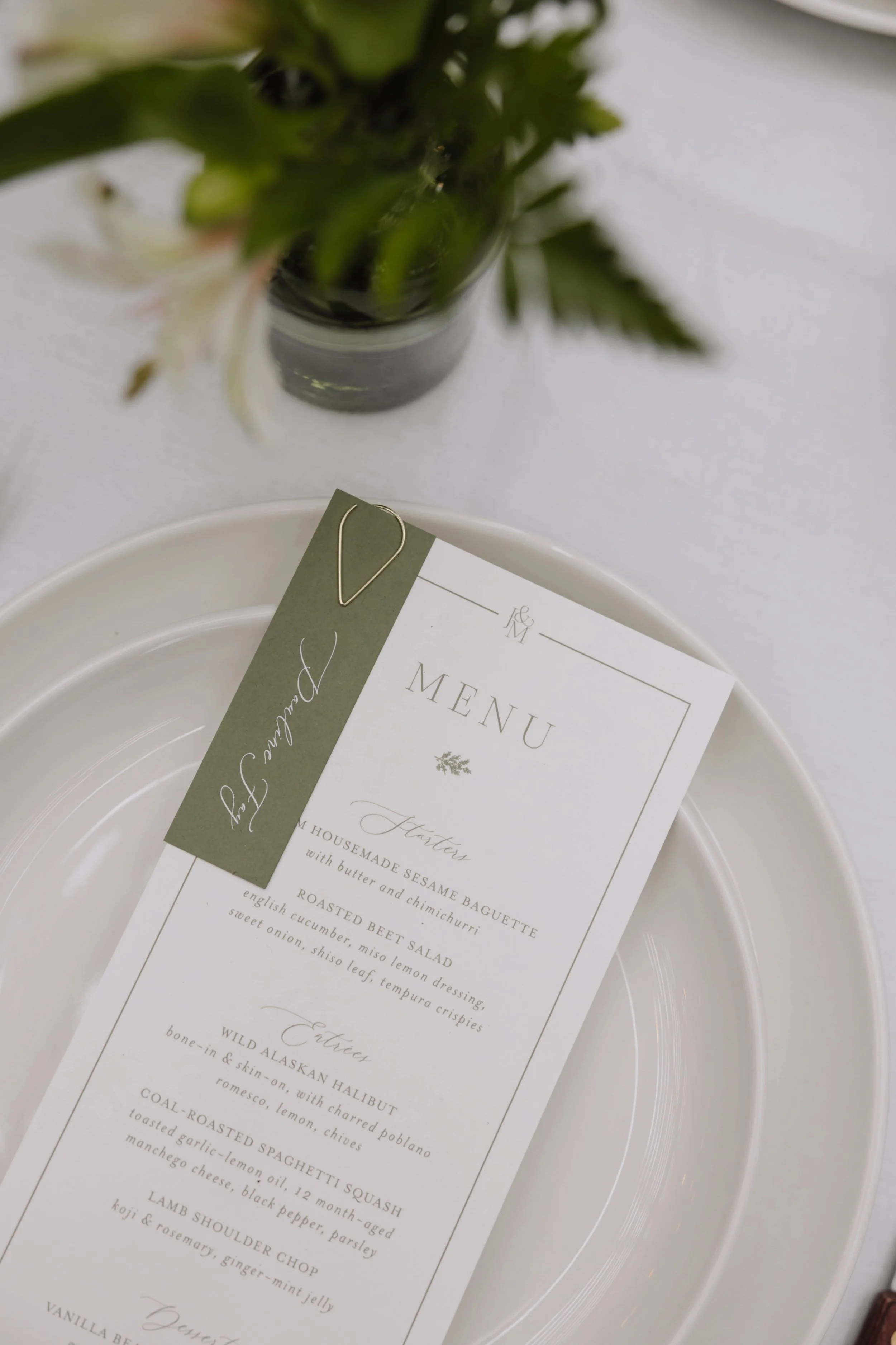 Dinner menu for wedding at the Ox Restaurant in Portland, Oregon with custom art and typography, monogram of bride and groom's initials, and place card attached with a metal clip