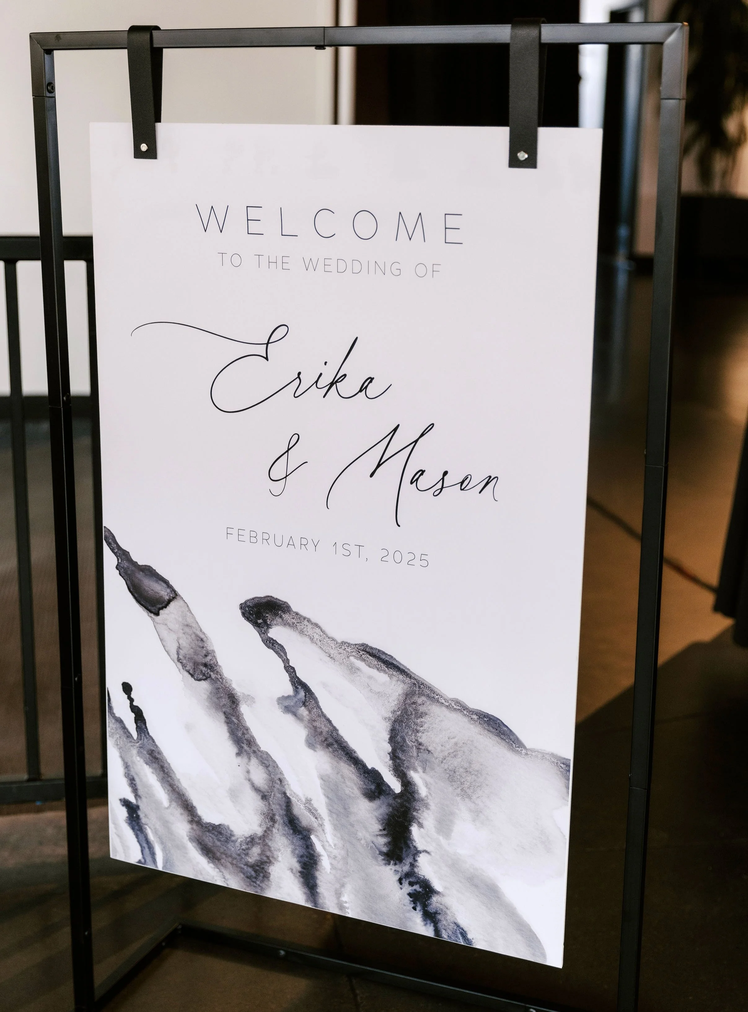 wedding welcome sign hanging from metal stand with black and white marbled watercolor