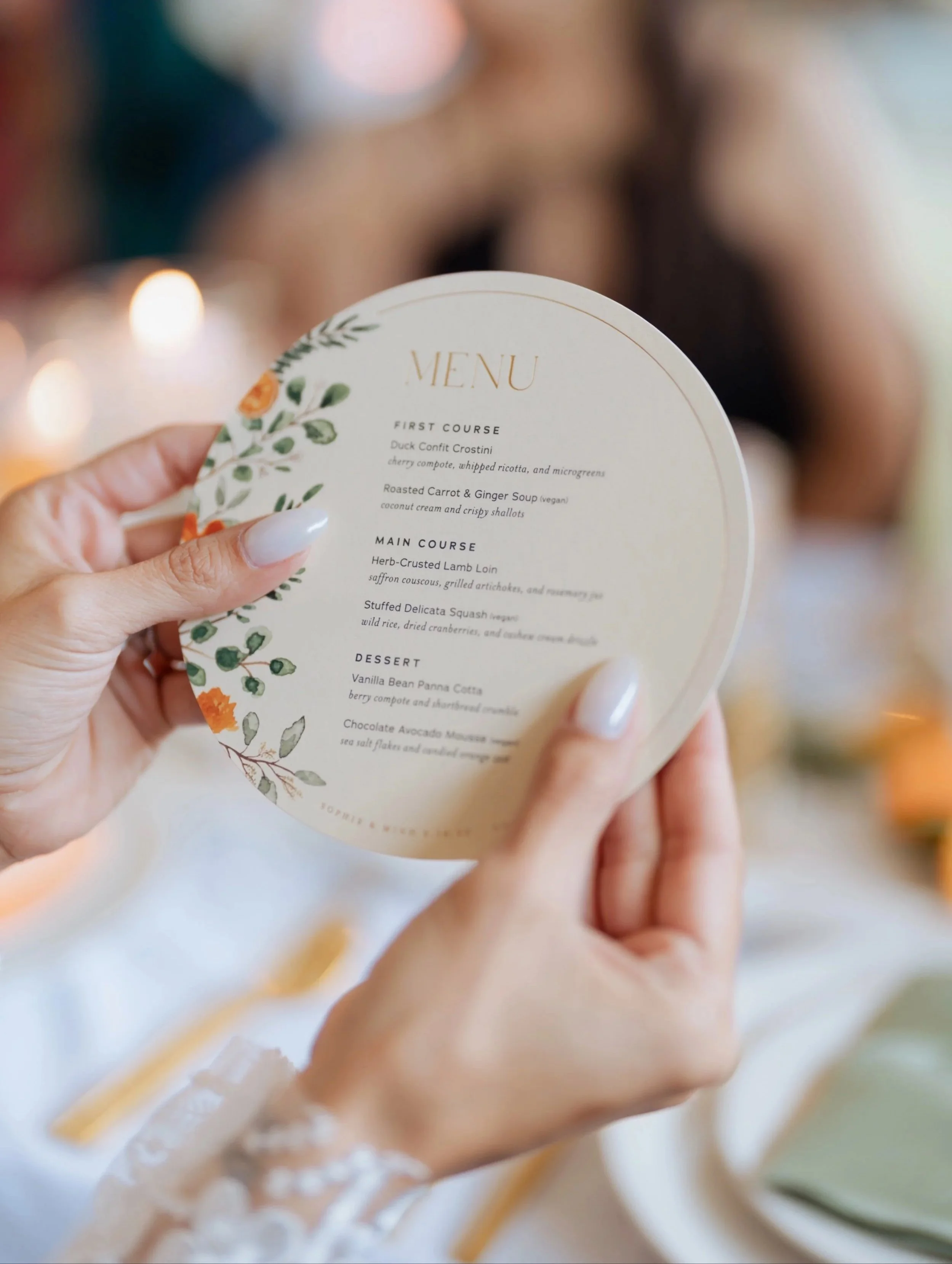 Bride holding a dinner menu with circular paper shape, citrus slices, flowers and leaves with typography for a wedding at the Coopers Hall venue in Portland, Oregon