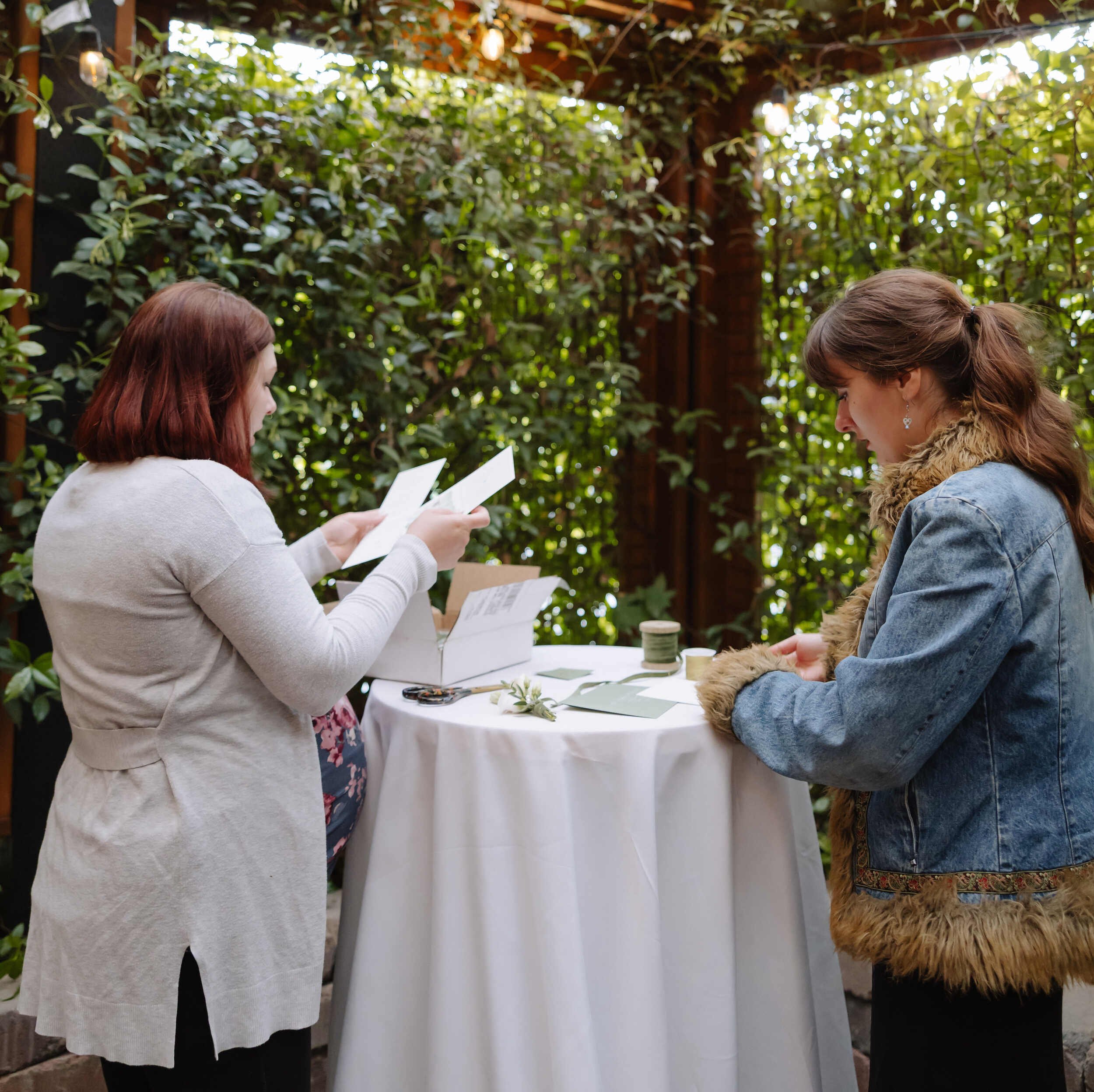 Michelle Roberts and Sophie Abbassian behind the scenes setup of a custom invitation suite flat lay for the Ox Restaurant venue in Portland, Oregon