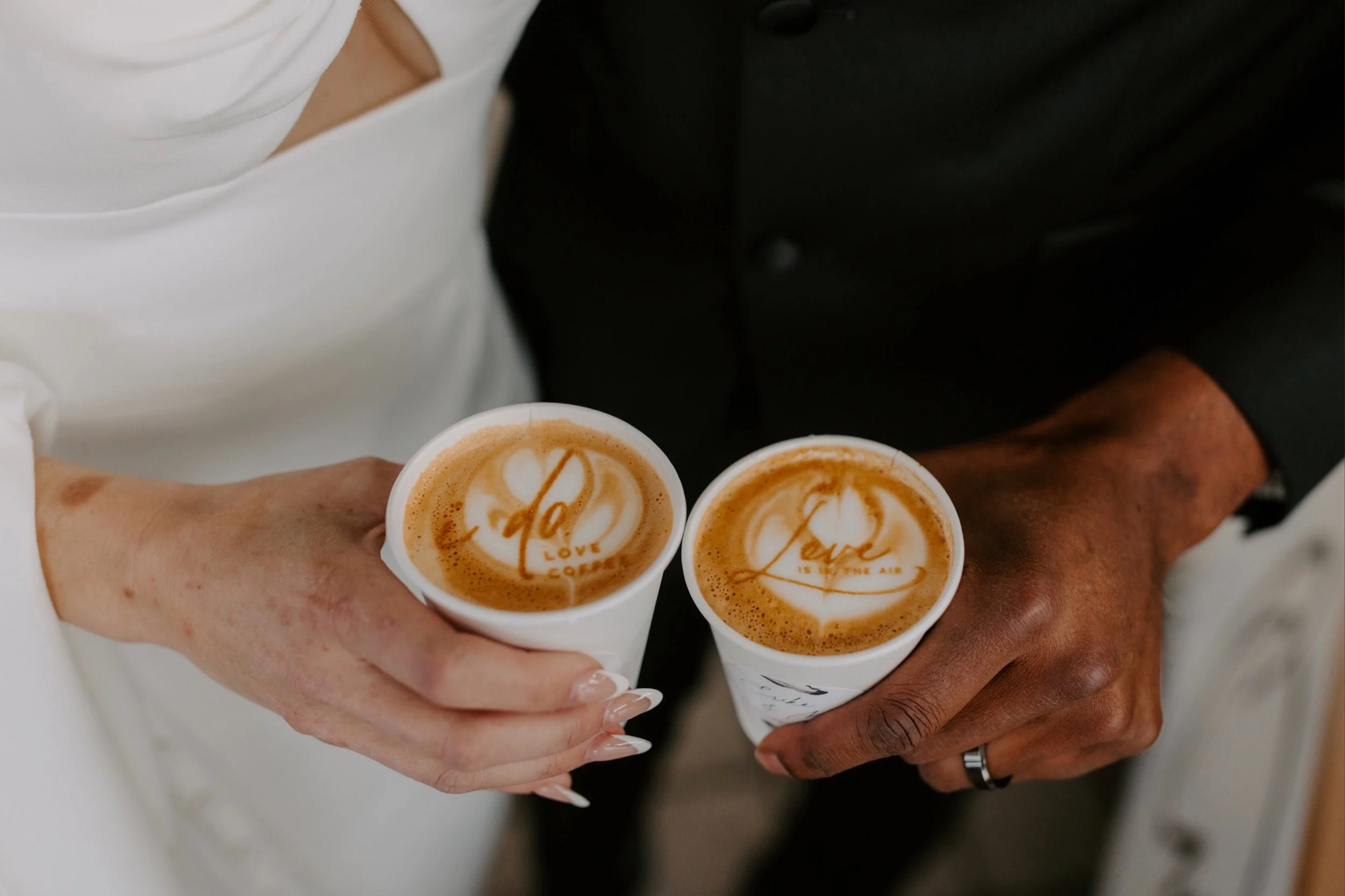 Bride and groom holding coffee cups with custom printed stencils and sticker label design on cup