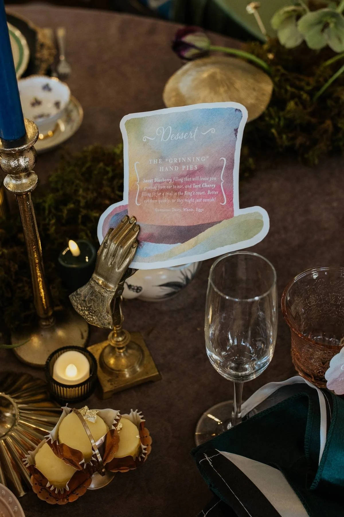 Alice in Wonderland wedding theme tea party table setting colorful watercolor dessert menu in the shape of a top hat with antique holder