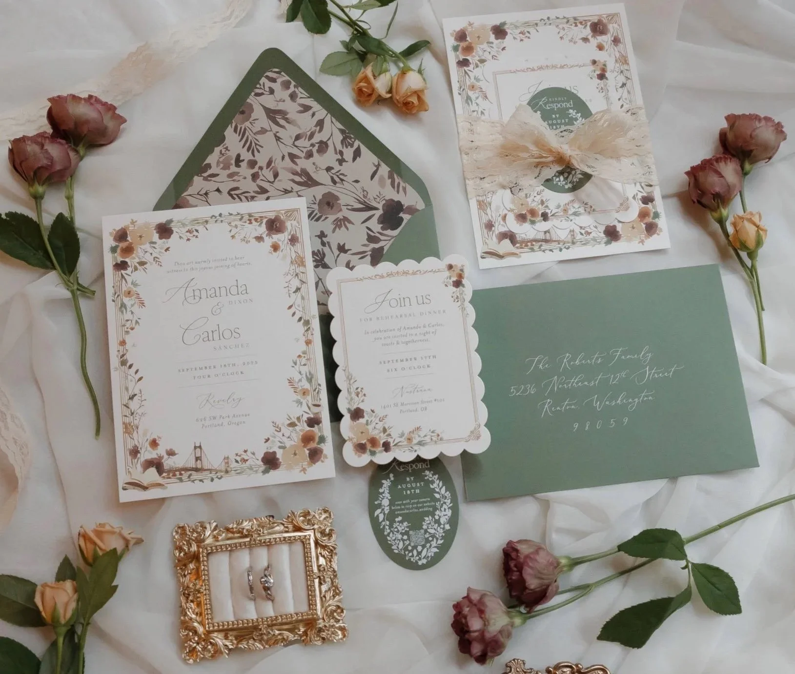 Wedding invitation suite flat lay with custom watercolor art of trailing flower borders and local Portland landmarks like the St Johns bridge and icons of a book and coffee cup