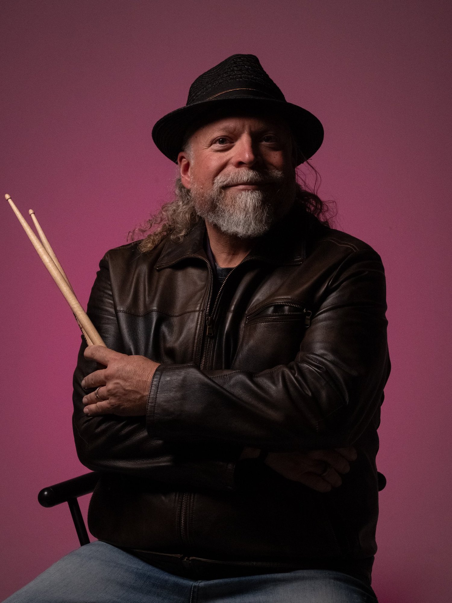 Chris Gamper of GamperDrums seated with drumsticks in a studio portrait
