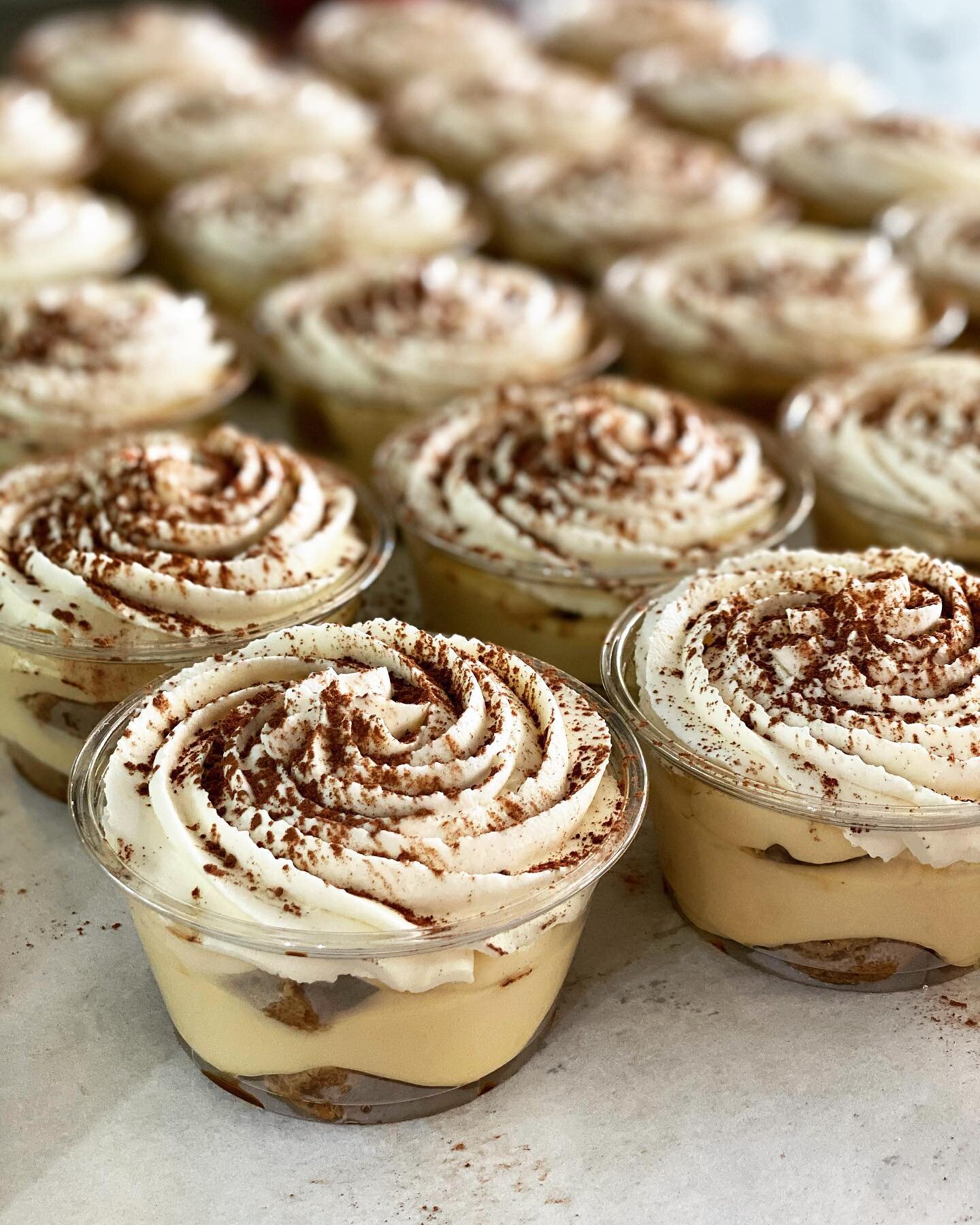 Petite tiramisu cups made with layers of creamy mascarpone, ladyfingers, and topped with vanilla bean whipped cream + cocoa powder.