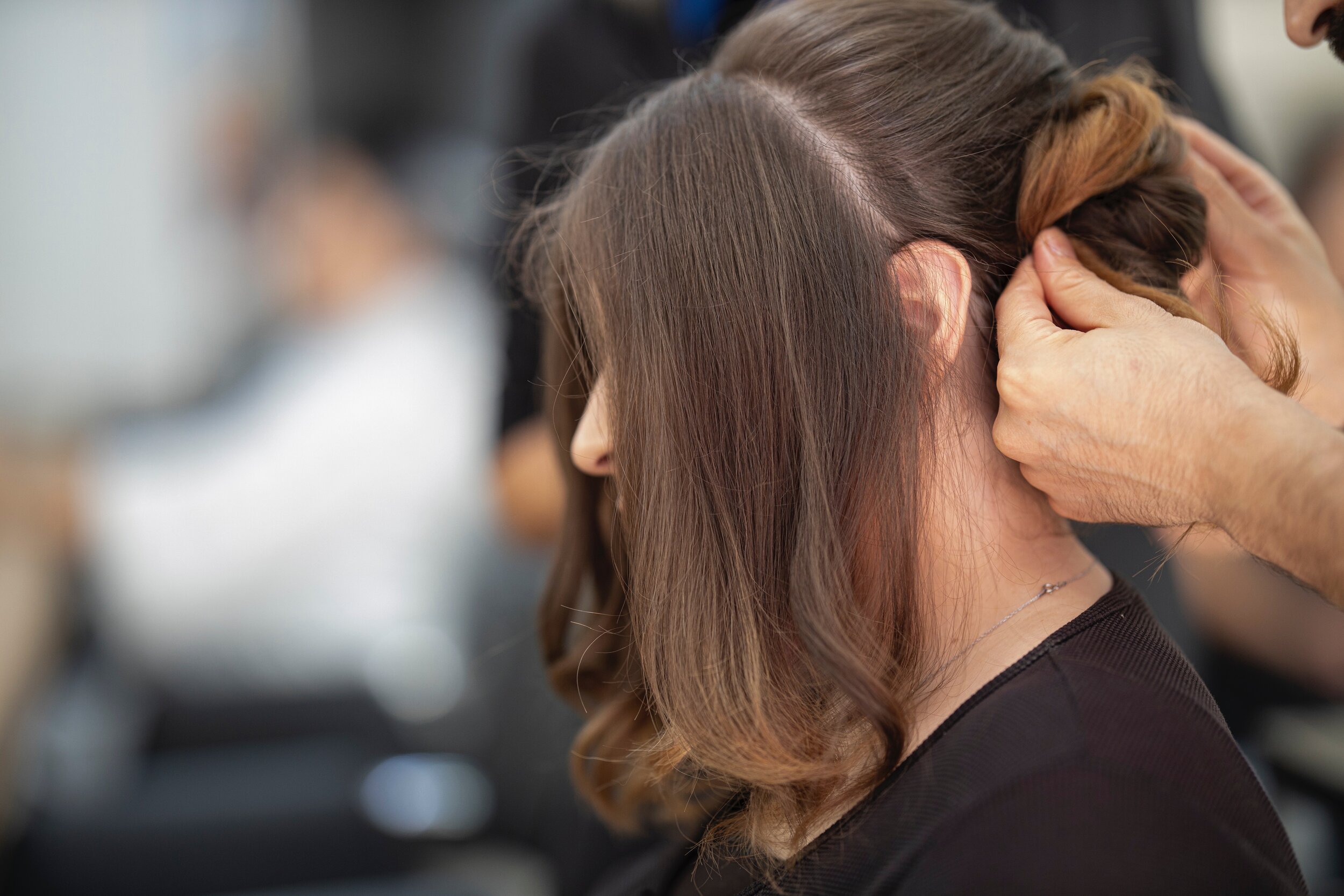 A stylist finishing a model's hair at Maximum FX Salon