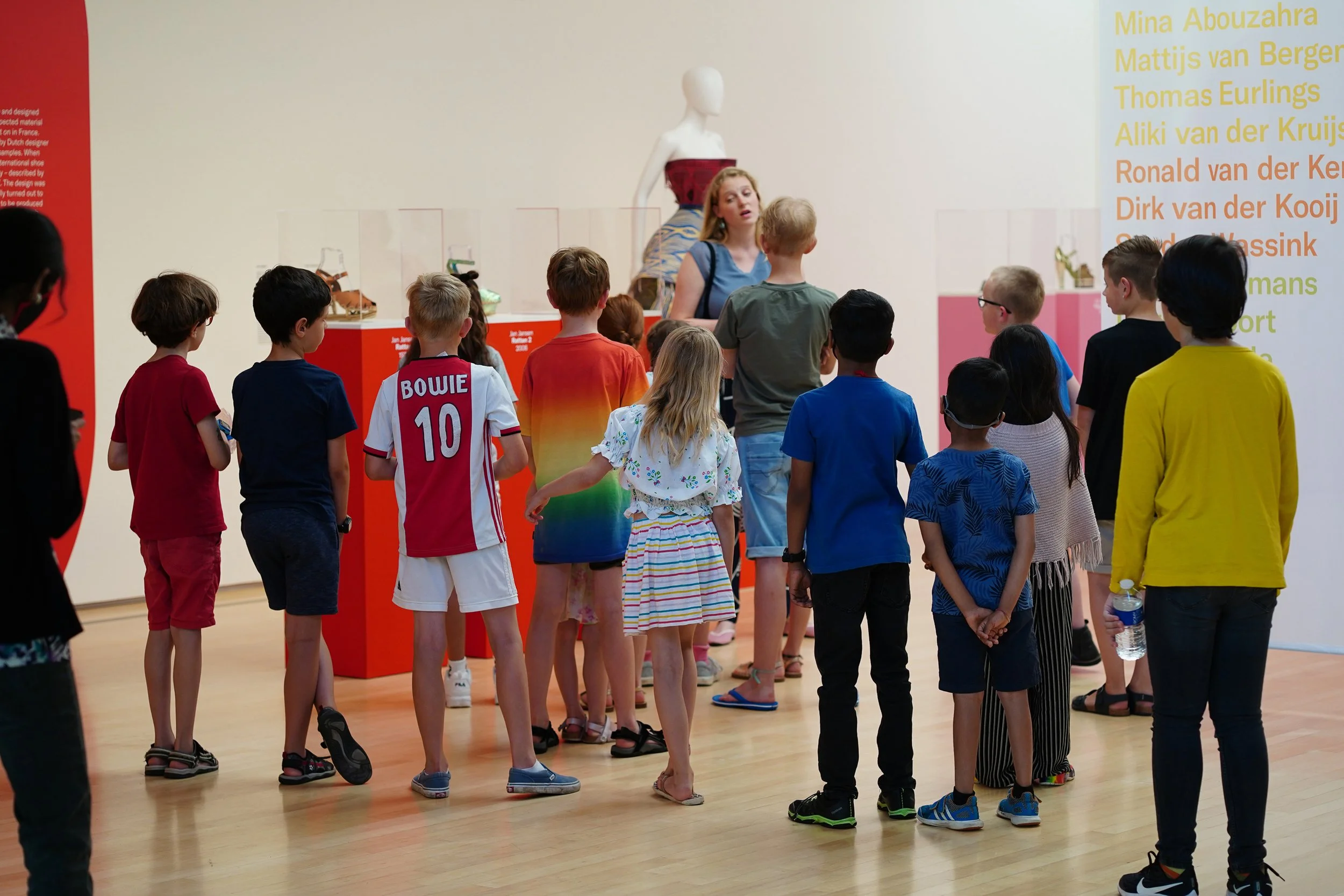 Een klas van de basisschool in het museum, die een rondleiding krijgen over de kunst