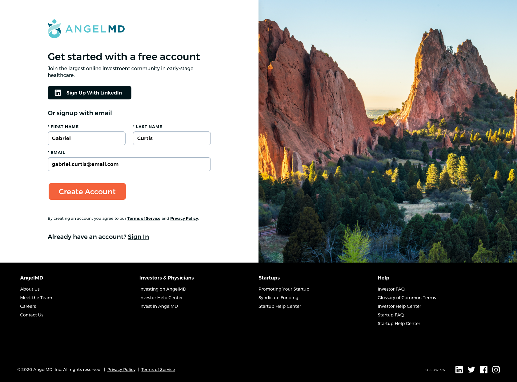 Sign up page for AngelMD with a background image of Red Rocks in Colorado, featuring large red rock formations and a forest of green trees.
