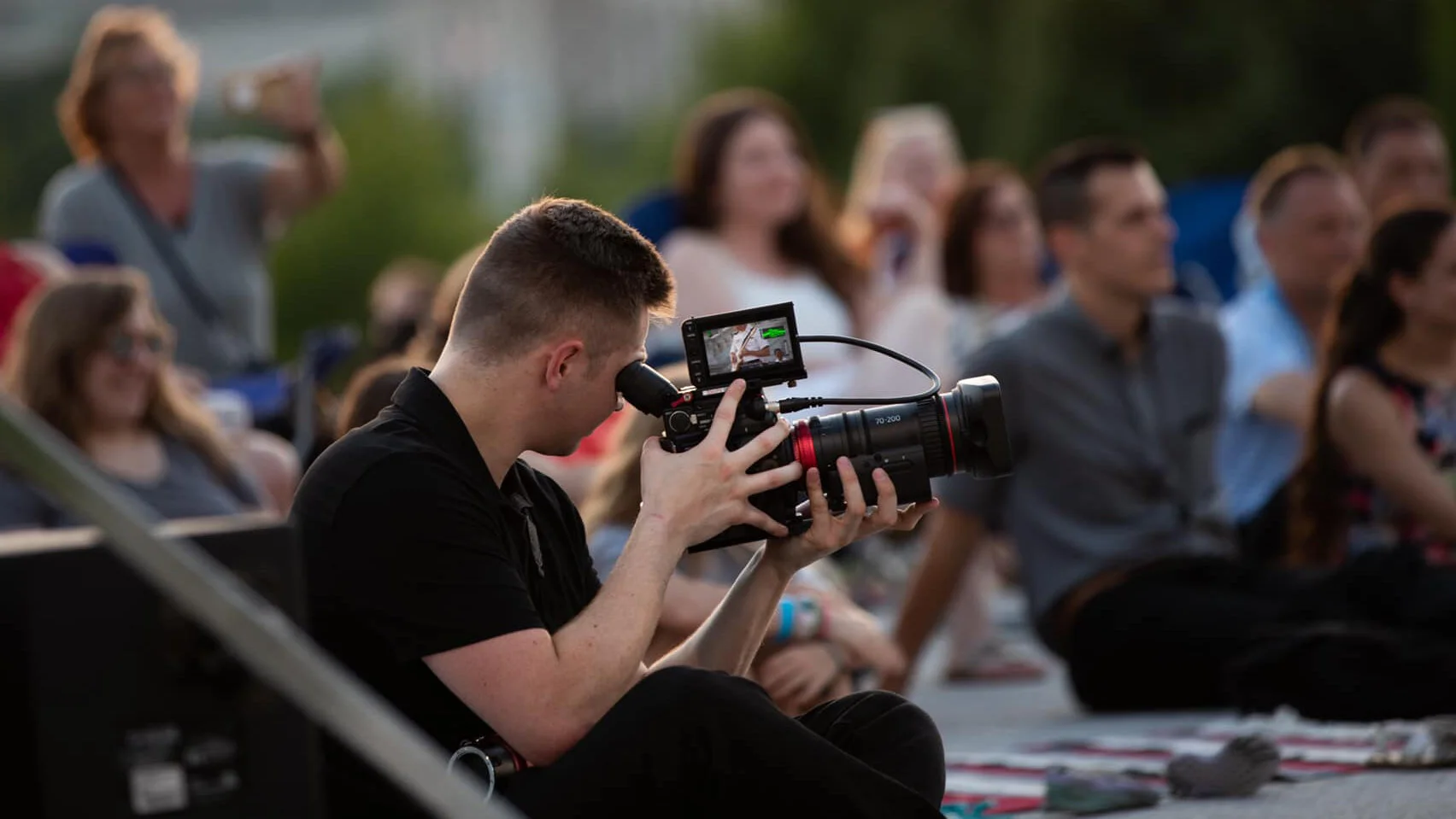 Artie Bowman filming in a crowd.