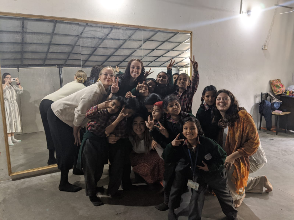 student with children from pyds while on community internship in india.png