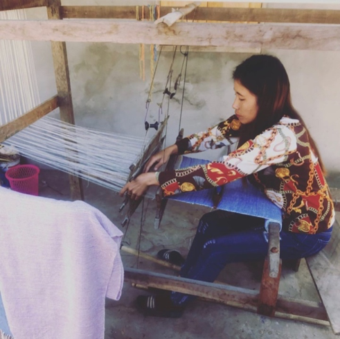 Laos female demonstrates traditional weaving.png